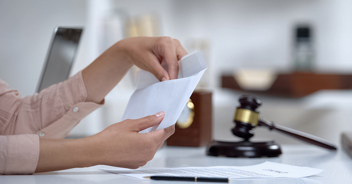 Woman's hands opening envelope