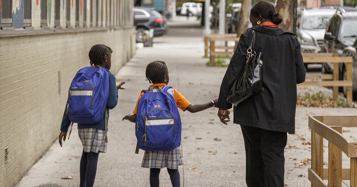 Mom walking her kids to school in an urban environment