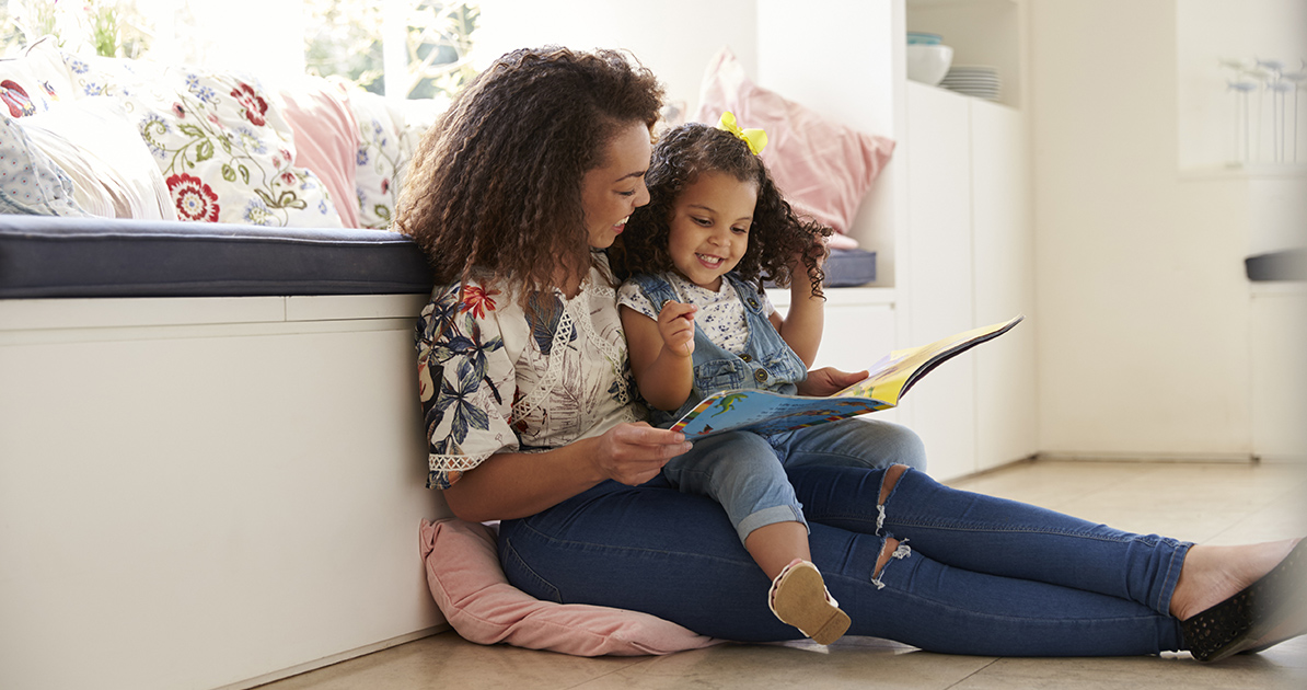 Mother reading a storybook to young daughter