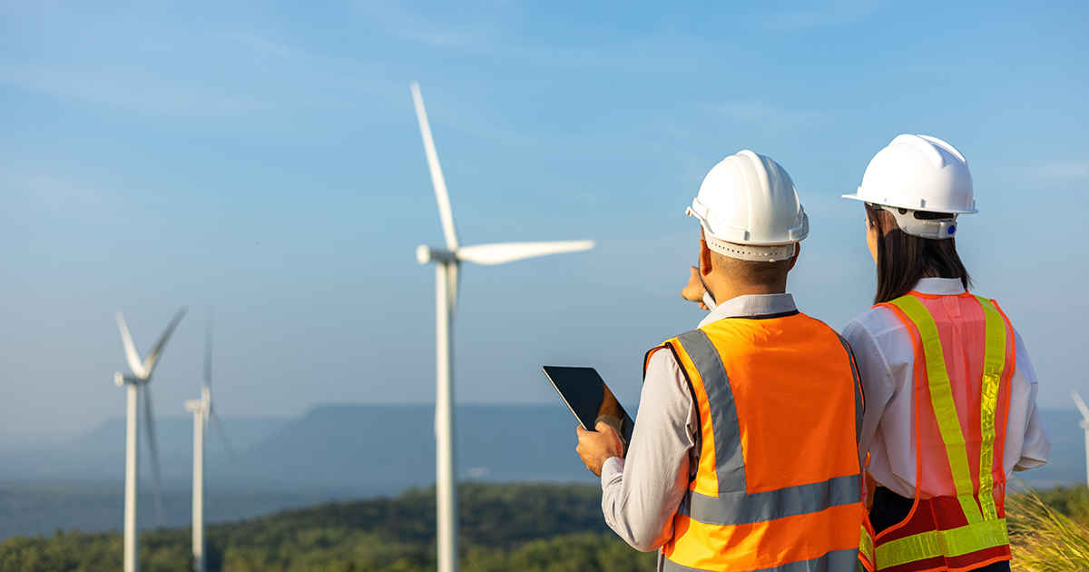 Two engineers surveying a windmill farm