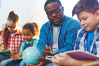 Teacher assisting young students