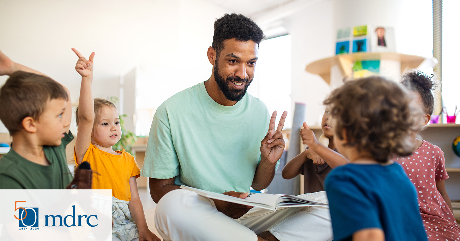 Male pre-K teacher teaching numbers to diverse group of kids