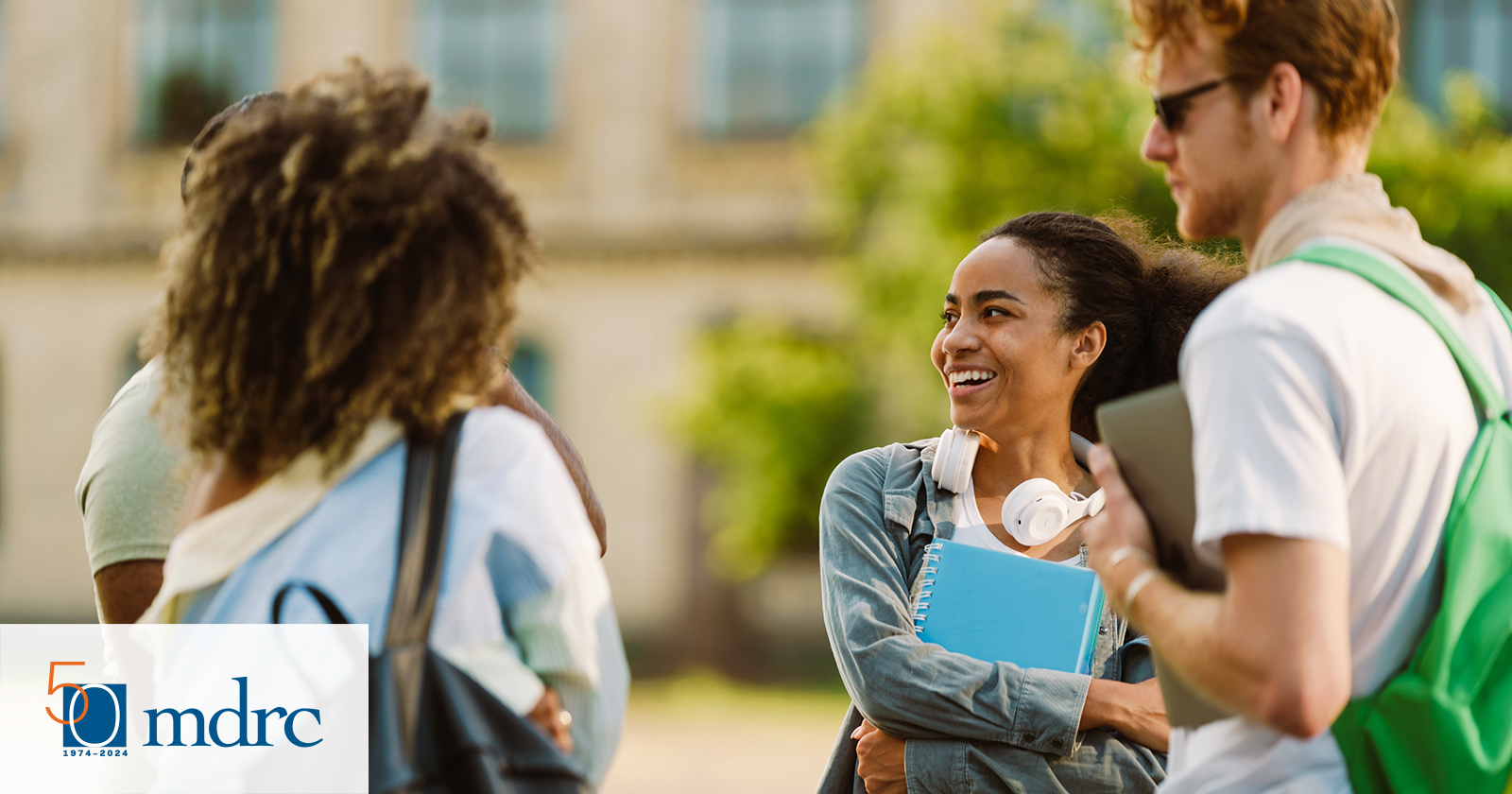 Diverse group of college students talking with each other outdoors