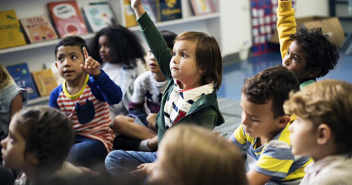 Group of young students with raised hands