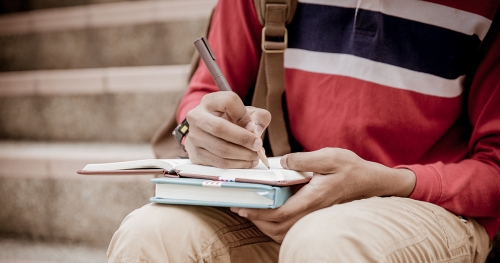 a student is writing in a notebook