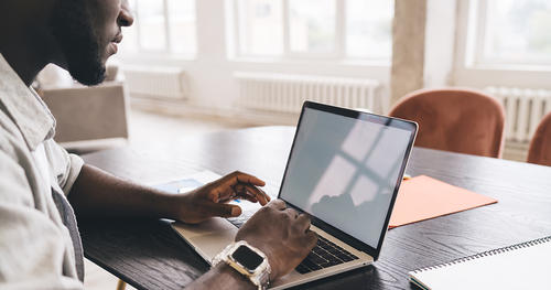 Black man typing on laptop