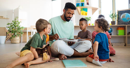 a man in a floor surraunded by kids