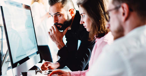 Colleagues reviewing information on a computer together