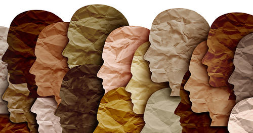 Overlapping paper silhouettes of heads in different shades of brown and pink