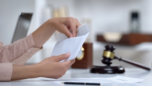 Woman's hands opening envelope