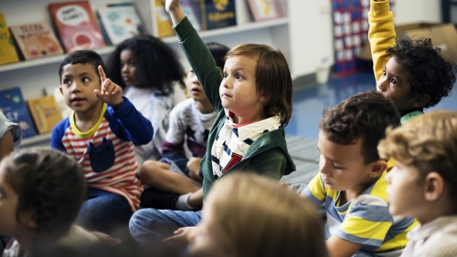 Group of young students with raised hands