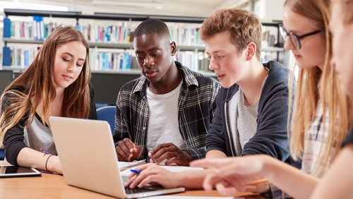 Group of college students reviewing a document together