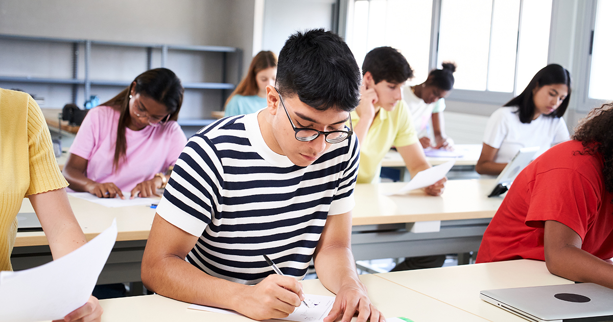 college students in the auditorium writing an exam