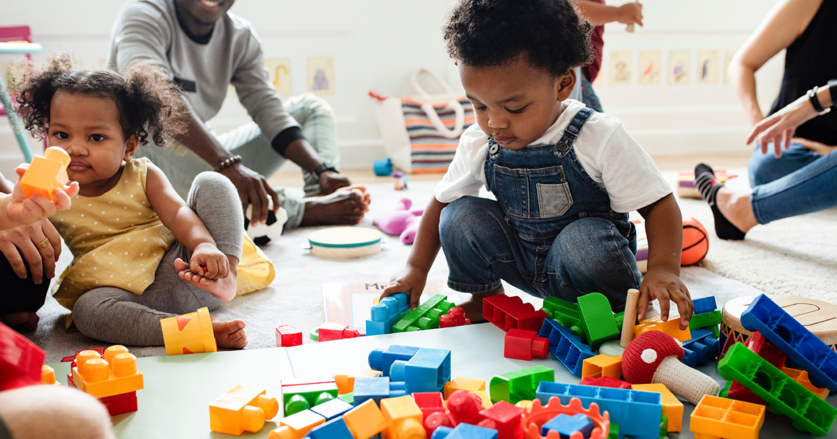 small kids are playing with toys on a floor