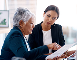 Two colleagues reviewing information on a piece of paper