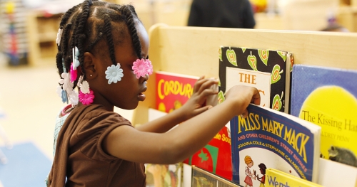 Young girl looks at books in a library