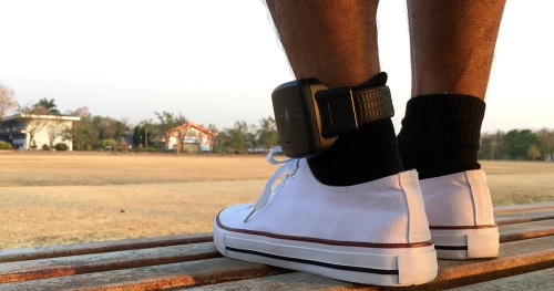 a man's feet with police braslet