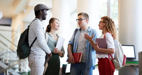 Diverse group of college students chatting in a library