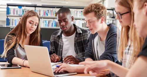 Group of college students reviewing a document together